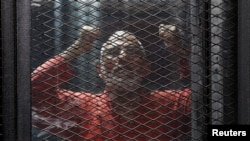 Pemimpin Ikhwanul Muslimin, Mohamed Badie, dibalik penjara dalam persidangan di pengadilan di pinggir Kota Kairo, Mesir, 31 Mei 2016.