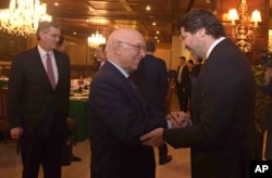 Afghanistan’s deputy foreign minister, Hekmat Khalil Karzai, right, and Pakistani foreign affairs adviser Sartaj Aziz exchange greetings before a four-nation meeting to develop a peace process for Afghanistan.