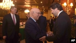 FILE - In this photo released by Associated Press of Pakistan, Afghanistan Deputy Foreign Minister, Hekmat Khalil Karzai, right, shakes hands with Sartaj Aziz, adviser to the Pakistani prime minister on foreign affairs, prior to a meeting of delegates from Pakistan, Afghanistan, China and the United States, in Islamabad, Pakistan, Jan. 11, 2016. Richard Olson, U.S. Special Representative for Afghanistan and Pakistan is seen at left. 