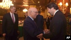 Afghanistan’s deputy foreign minister, Hekmat Khalil Karzai, right, and Pakistani foreign affairs adviser Sartaj Aziz exchange greetings before a four-nation meeting to develop a peace process for Afghanistan. Richard Olson, U.S. special representative fo