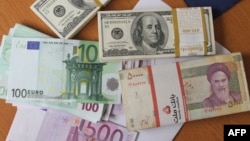 FILE - The euro and United States $100 bill are seen next to Iran's rial.