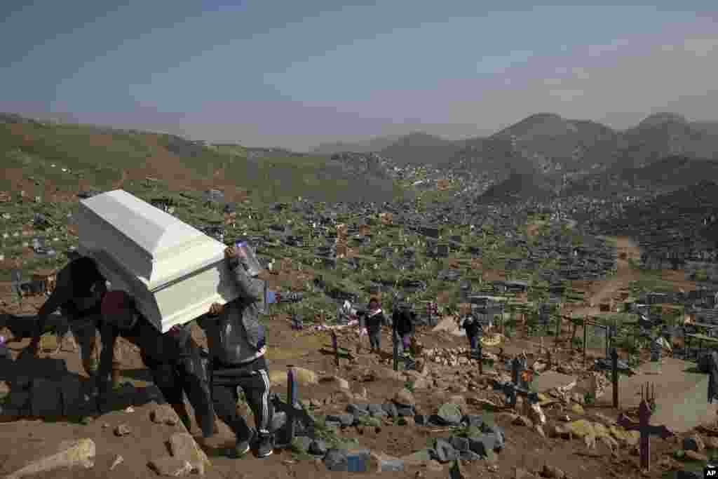 Relatives carry the coffin of a loved one during a burial in the section of the Nueva Esperanza cemetery reserved for COVID-19 cases, in the outskirts of Lima, Peru, Sept. 21, 2020.