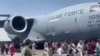 Ratusan orang berlarian di samping pesawat angkut C-17 Angkatan Udara AS saat bergerak di landasan bandara internasional, di Kabul, Afghanistan, Senin, 16 Agustus 2021. (Verified UGC via AP)

