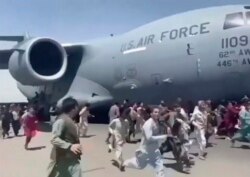 Ratusan orang berlari di samping pesawat Angkatan Udara AS di landasan bandara internasional, di Kabul, Afghanistan, Senin, 16 Agustus 2021. (Foto: AP)