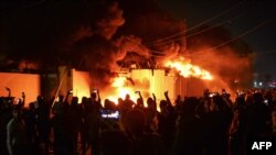 Iraqi demonstrators gather as flames start consuming Iran's consulate in the southern Iraqi Shiite holy city of Najaf on Nov. 27, 2019.