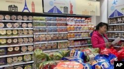 一名消费者在北京一家商场购买进口食品(资料照)