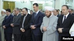 Syria's President Bashar al-Assad (3nd R ) attends Eid Al Fitr prayers at al-Hamad mosque in Damascus, August 19, 2012.