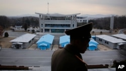 FILE - North Korean People's Army Lt. Col. Nam Dong Ho is silhouetted against the truce village of Panmunjom at the Demilitarized Zone (DMZ) which separates the two Koreas on Monday, Feb. 22, 2016. Critics say a confrontational approach to North Korean provocations has fueled regional tensions.