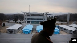 FILE - North Korean People's Army Lt. Col. Nam Dong Ho is silhouetted against the truce village of Panmunjom at the Demilitarized Zone (DMZ) which separates the two Koreas on Monday, Feb. 22, 2016.