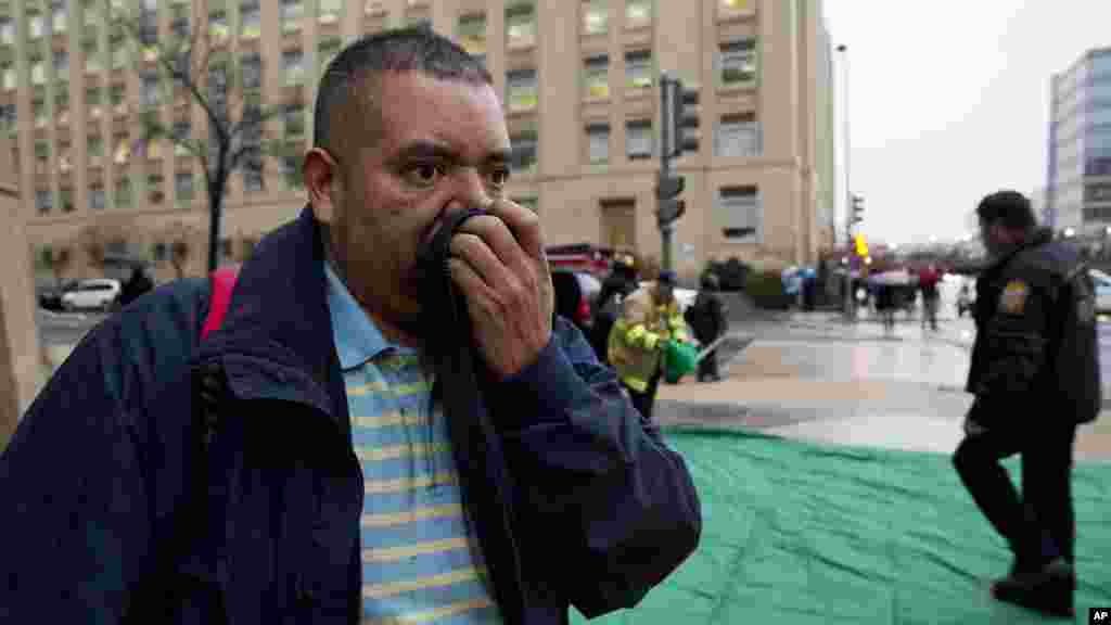 Reynaldo Hernandez se couvre le nez pendant qu&#39;il tousse interminablement après avoir été évacués d&#39;un&nbsp;tunnel enfumé de métro à Washington, lundi 12 janvier, 2015. 