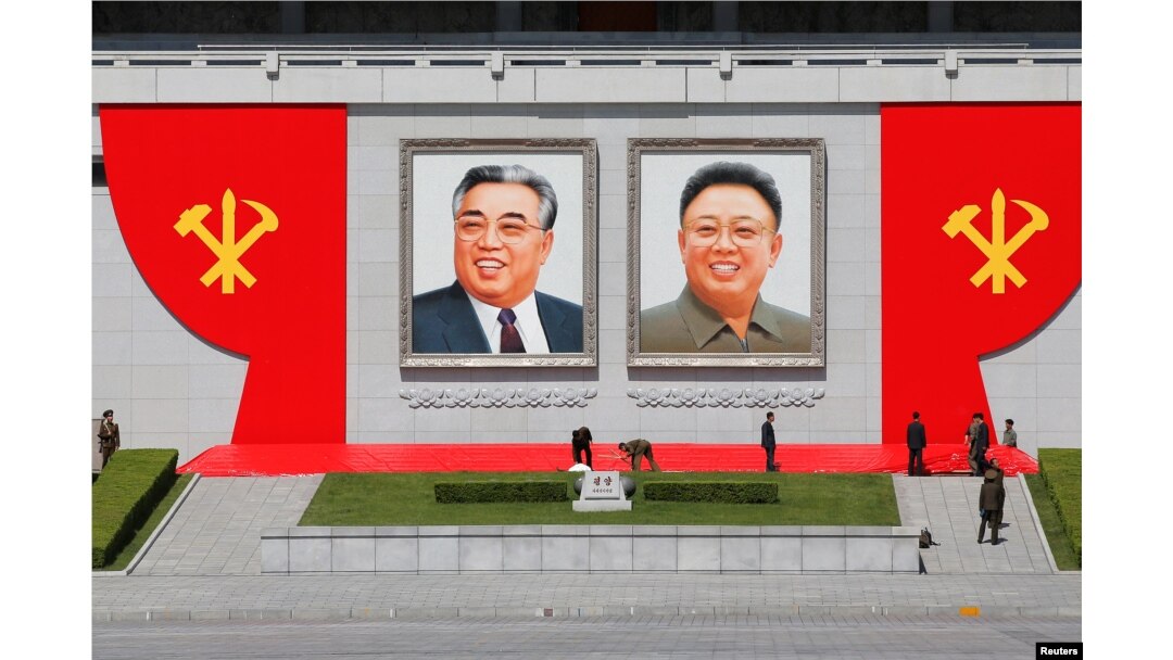 FILE - People work around pictures of former North Korean leaders Kim Il Sung, left, and Kim Jong Il at the main Kim Il Sung square in central Pyongyang, North Korea, May 7, 2016.