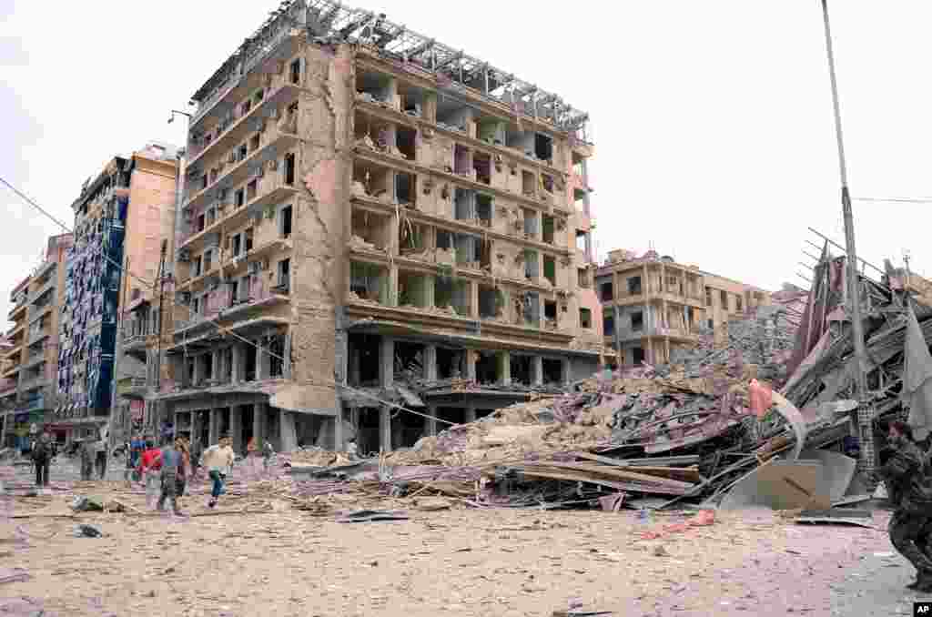 This photo released by the Syrian official news agency SANA shows Syrian security officers in front of destroyed buildings where bombs exploded in Saadallah al-Jabri square, in Aleppo, Syria, October 3, 2012.