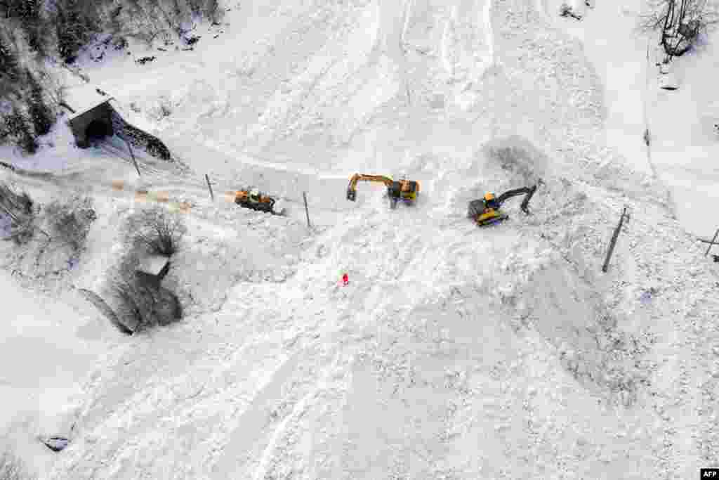 Excavators remove the snow on the site of an avalanche that covered the railway of the Brig Visp Zermatt Bahn company between Visp and Taesch near Sankt Niklaus, Swiss Alps.