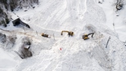 Ekskavator membersihkan salju di lokasi longsor yang menutupi rel kereta api milik perusahaan Brig Visp Zermatt Bahn antara Visp dan Taesch pada 10 Januari 2018 di dekat Sankt Niklaus, Pegunungan Alpen Swiss. (Foto: AFP)