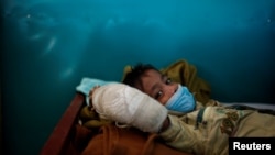 FILE - Rohingya refugee Yasin Arfat, 6, who suffers from diphtheria, lays on a bed at a Medecins Sans Frontieres (MSF) clinic near Cox's Bazar, Bangladesh.