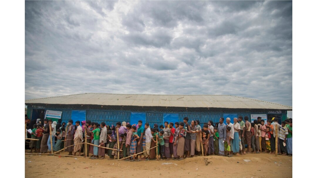 FILE - Rohingya Muslims, who crossed over from Myanmar into Bangladesh, wait in queues to receive aid at Kutupalong refugee camp in Ukhiya, Bangladesh, Nov. 15, 2017.