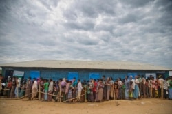 FILE - Rohingya Muslims, who crossed over from Myanmar into Bangladesh, wait in queues to receive aid at Kutupalong refugee camp in Ukhiya, Bangladesh, Nov. 15, 2017.