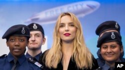 Jodie Comer (tengah), berpose bersama taruna Polisi Metropolitan setibanya di lokasi pemutaran perdana film 'Free Guy' di London, Senin, 09 Agustus 2021. (AP Photo/Scott Garfitt)