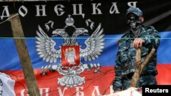 Un separatista prorruso observa desde una barricada en Slaviansk, mientras Kiev dice haber lanzado una operación para desalojarles.