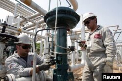 FILE - Oil workers conduct routine maintenance on a gas plant at field Boscan, operated under a joint venture model between Venezuelan state oil company PDVSA and U.S. Chevron, outside Maracaibo City in Venezuela, May 26, 2006.