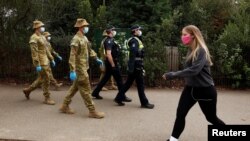 نیروهای دفاعی استرالیا و پلیس ایالت ویکتوریا در حال گشت زنی در ملبورن در استرالیا. ۲۶ ژوئیه ۲۰۲۰
