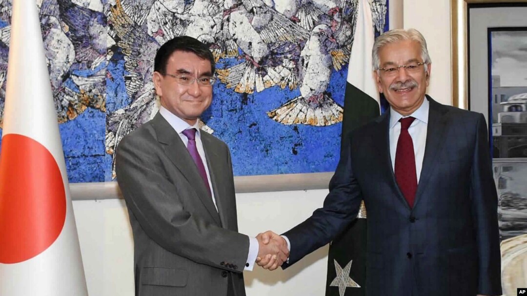 Menlu Pakistan Khawaja Asif (kanan) berjabat tangan dengan Menlu Jepang Taro Kono di Islamabad, Pakistan, 4 Januari 2018.