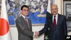 Menlu Pakistan Khawaja Asif (kanan) berjabat tangan dengan Menlu Jepang Taro Kono di Islamabad, Pakistan, 4 Januari 2018.