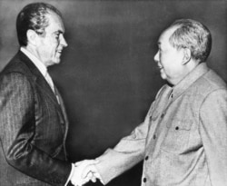 FILE - U.S. President Richard M. Nixon, left, shakes hands with Chinese communist party leader Chairman Mao Zedong during Nixon's groundbreaking trip to China, in Beijing, Feb 21, 1972.