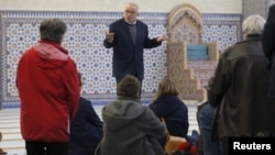 People listen to the explanations of guide Mohamed Latahi (C), as they visit the Strasbourg Grand Mosque during an open day weekend for mosques in France, Jan. 9, 2016. 