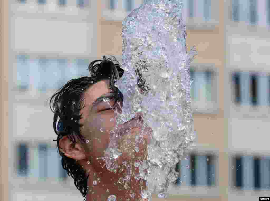 آب بازی در میان فواره ها در یک روز تابستانی گرم در بروکسل پایتخت بلژیک &nbsp;