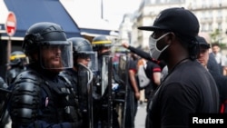 Seorang demonstran berhadapan dengan polisi anti huru-hara dalam unjuk rasa memprotes kebrutalan polisi dan ketidakadilan ras, di Paris, Perancis, 20 Juni 2020. (Foto: Reuters)