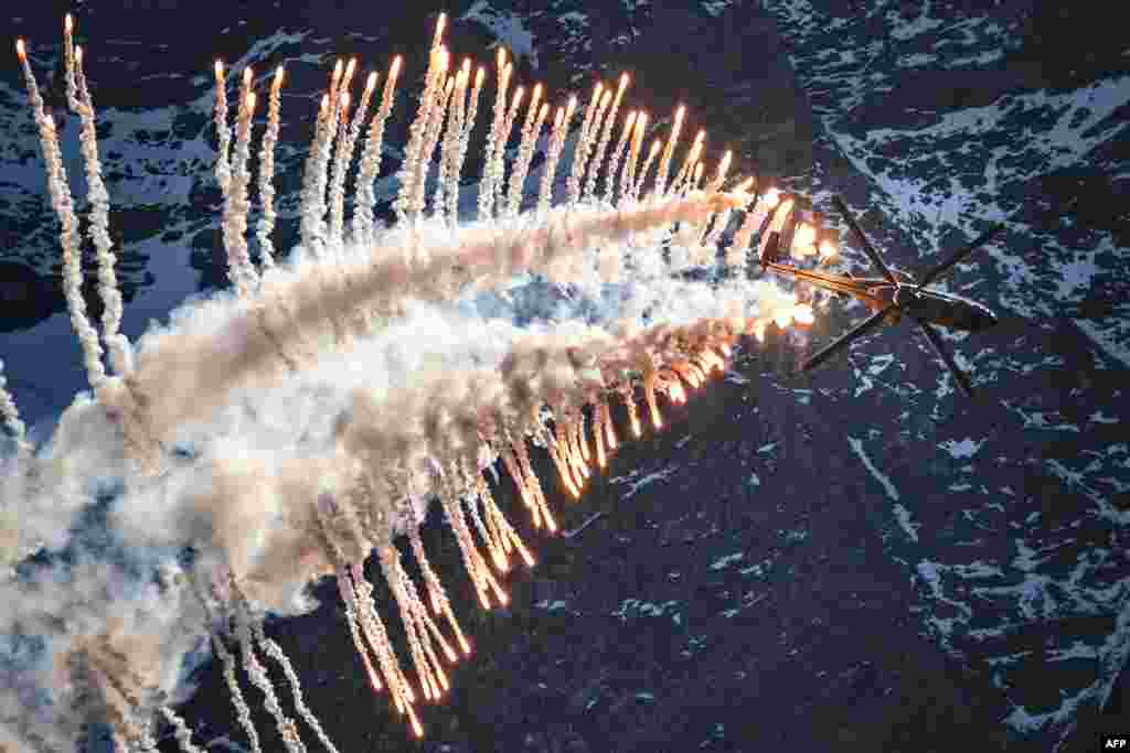 Super Puma Cougar helicopter releases flares over Brienz in the Bernese Alps during the annual live fire event of the Swiss Air Force at the Axalp, Switzerland.