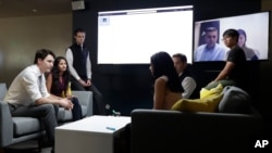 FILE - Canada's Prime Minister Justin Trudeau, left, speaks with AppDirect employees at their office in San Francisco, Feb. 8, 2018. Trudeau was pitching Canada as a destination for U.S. tech firms amid increasing unease over U.S. immigration policy.