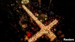 Worshipers gather around candles stuck to jars with honey, during a religious mass in the church of the Presentation of the Blessed Virgin in Blagoevgrad, Bulgaria February 10, 2016. 