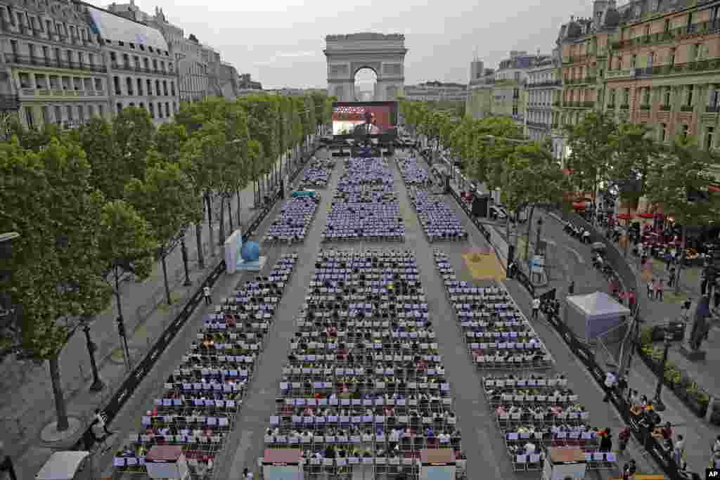 People watch a free outdoor movie screened on the Champs Elysees avenue in Paris, France, July 7, 2019.