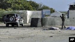 A Somali government soldier looks at a car laden with explosives which targeted Mogadishu airport, 09 Sep 2010