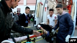 People help wounded a Syrian man in a Turkish hospital in Kilis, southern Turkey after an explosion near the border of Syria-Turkey in Es-Selame City, Feb. 20 , 2014.