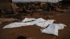 FILE - Dead bodies covered in plastic lie in front of a burnt out marketplace in Bor, South Sudan.
