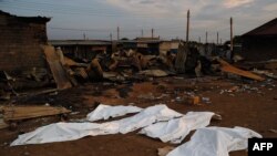 FILE - Dead bodies covered in plastic lie in front of a burnt out marketplace in Bor, South Sudan.
