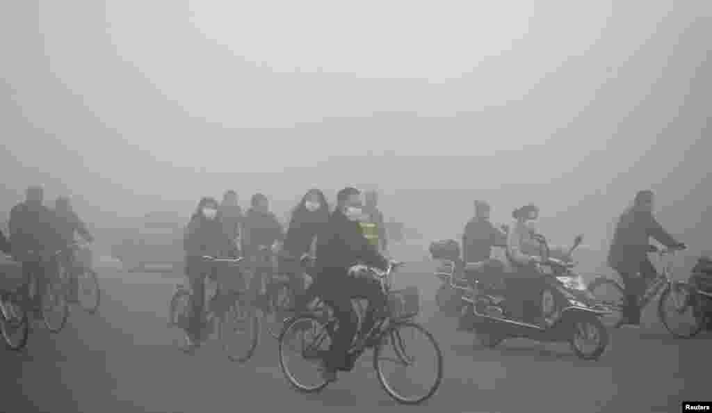 People ride along a street on a smoggy day in Daqing, Heilongjiang province, China, Oct. 21, 2013. 