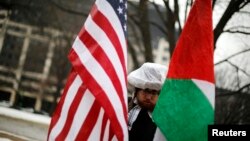 Un manifestant avec des drapeaux américains et palestiniens proteste silencieusement à Washington, le 1er mars 2015. (Archives)