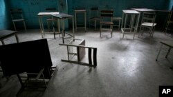 Desks and chairs sit in an abandoned classroom at a public high school in Caracas, Venezuela. Officially, Venezuela canceled 16 school days this year, including Friday classes because of an energy crisis, June 1, 2016. 