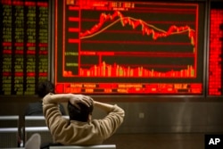 A Chinese investor monitors stock prices at a brokerage house in Beijing, Feb. 9, 2018.