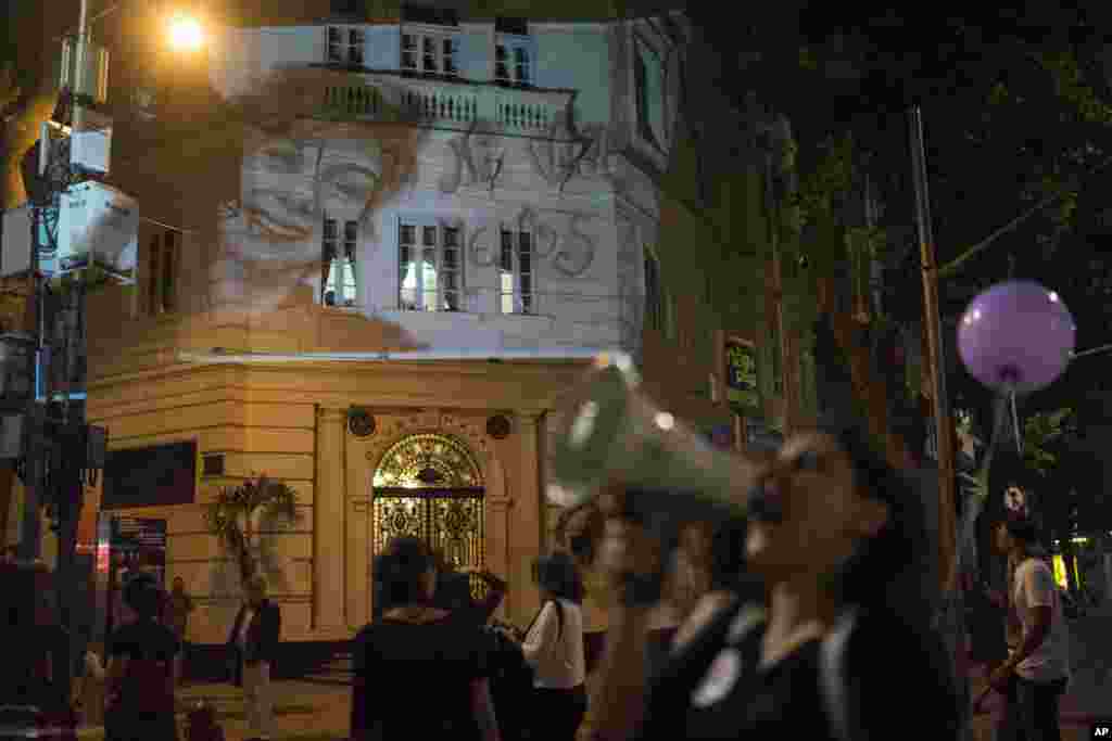 A photo of Lucia Perez,16, who was raped and killed in Argentina, is projected on a building as women participate in a demonstration against gender violence in Rio de Janeiro, Brazil, Oct. 25, 2016.