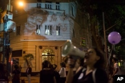 FILE - A photo of Lucia Perez,16, who was raped and killed in Argentina, is projected on a building as women participate in a demonstration against gender violence in Rio de Janeiro, Brazil, Oct. 25, 2016.
