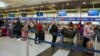 Passengers line up at John F. Kennedy International Airport after airlines announced numerous flights were canceled during the spread of the Omicron coronavirus variant on Christmas Eve in Queens, New York City, Dec. 24, 2021.