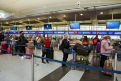 Passengers line up at John F. Kennedy International Airport after airlines announced numerous flights were canceled during the spread of the Omicron coronavirus variant on Christmas Eve in Queens, New York City, Dec. 24, 2021.