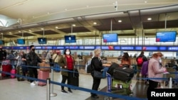 Los pasajeros hacen fila en el Aeropuerto Internacional JFK después de que las aerolíneas anunciaran la cancelación de numerosos vuelos durante la propagación de la variante del coronavirus ómicron, víspera de Navidad en Nueva York, el 24 de diciembre de 2022. 
