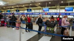 Passengers line up at John F. Kennedy International Airport after airlines announced numerous flights were canceled during the spread of the Omicron coronavirus variant on Christmas Eve in Queens, New York City, Dec. 24, 2021.