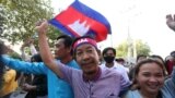 FILE - Rong Chhun, an environment activist, waves a Cambodian national flag after being released from the Correctional center in Phnom Penh, Cambodia, on November 12, 2021. (LICADHO/Raksmey Sok Handout via REUTERS)